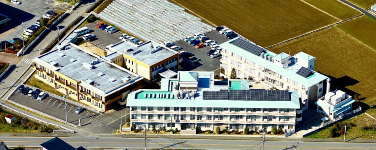 介護施設の航空写真。複数棟の建物と駐車場が見える全景
