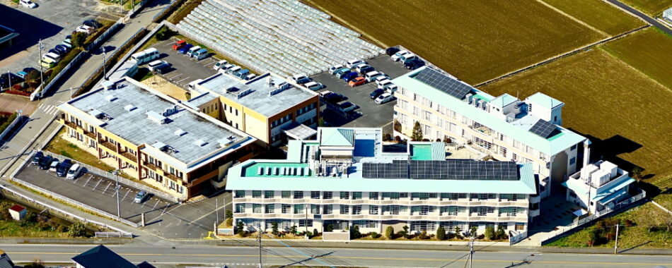 複数棟からなる介護施設の空撮。駐車場や周辺環境が見える
